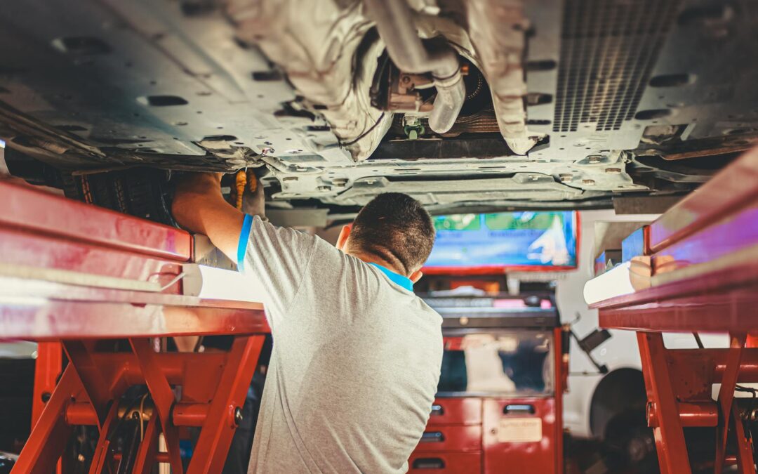 Auto repair reno mechanic working under a raised car performing inspection and maintenance in a professional shop