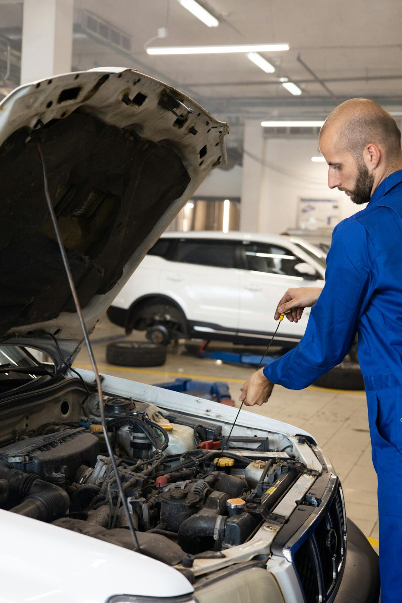 Technician working under the hood of a car at auto shop Reno