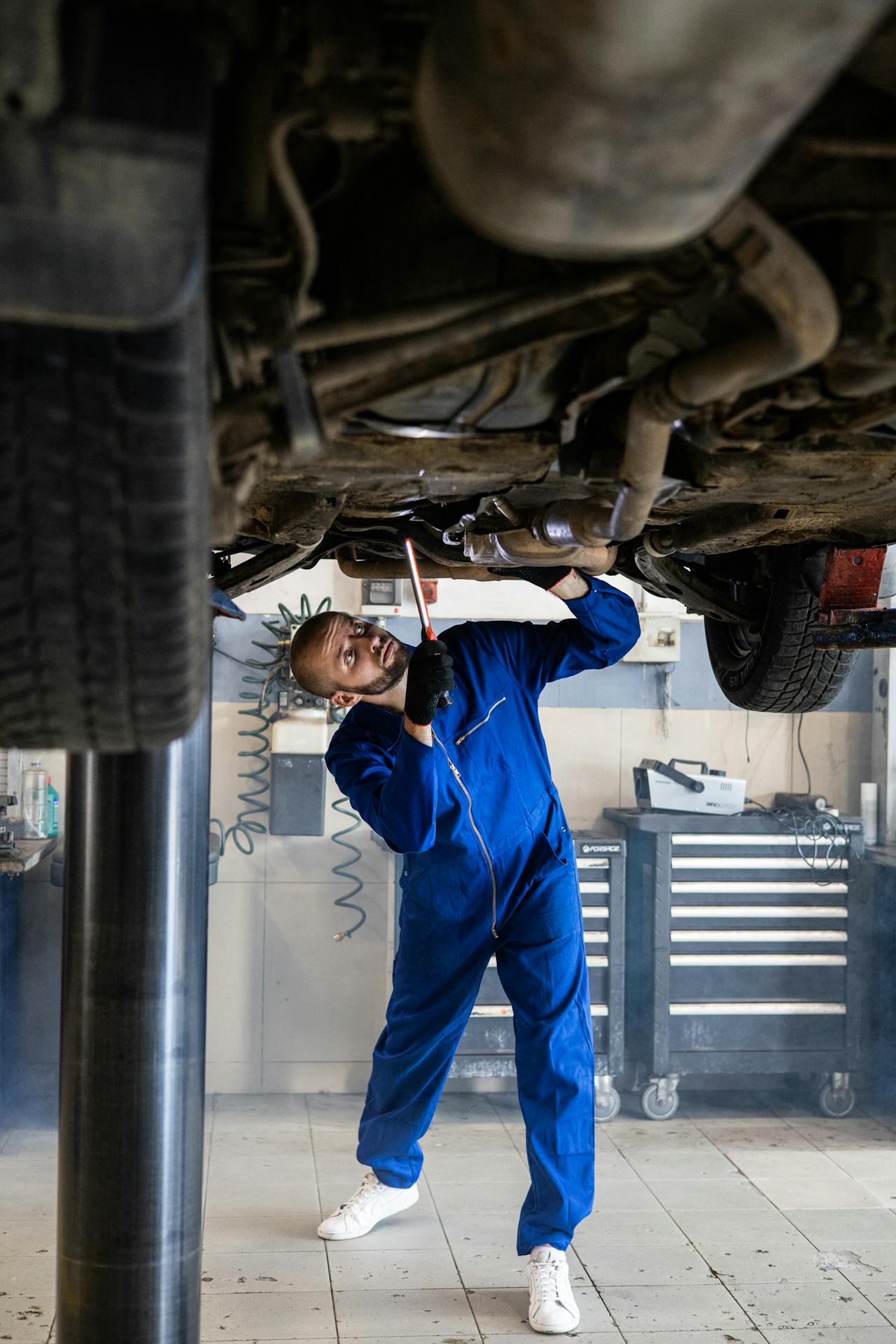 auto repair reno technician working under a raised car in a professional shop