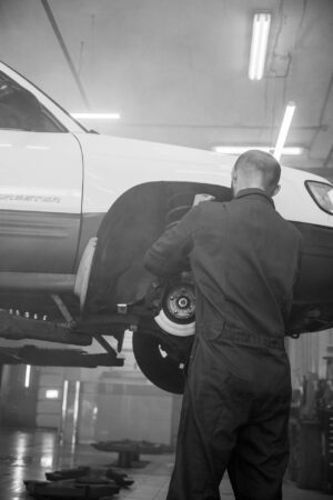 Man installing a new brake caliper during brake repairs to improve braking performance and vehicle safety